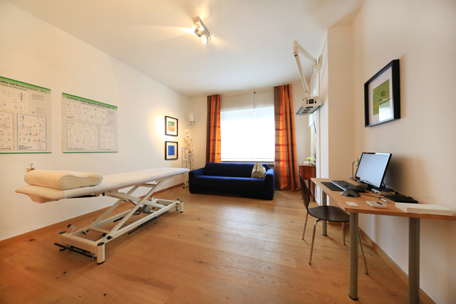 Blick in den großen Behandlungsrau mir blauem Sofa