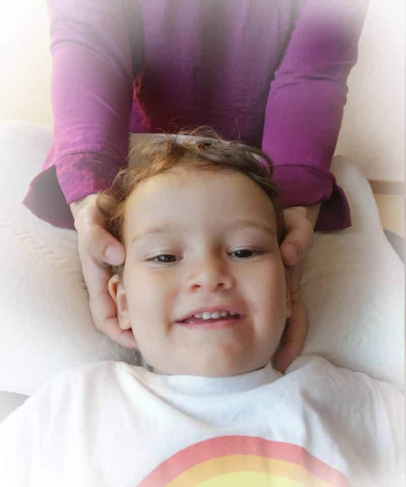 Craniosacrale Kinderosteopathie Behandlung am Kopf eines Kindes