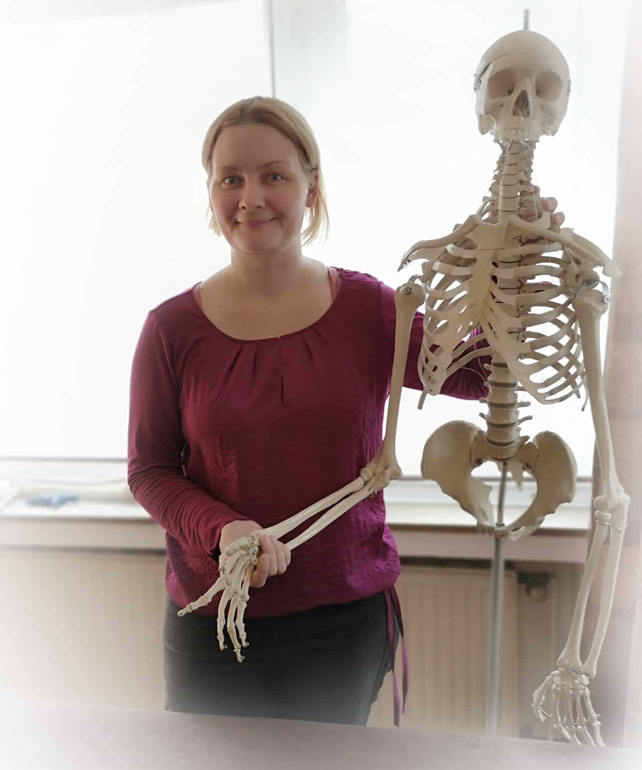 Osteopathin Petra Dorn neben einem Skelett in Osteopathie Köln